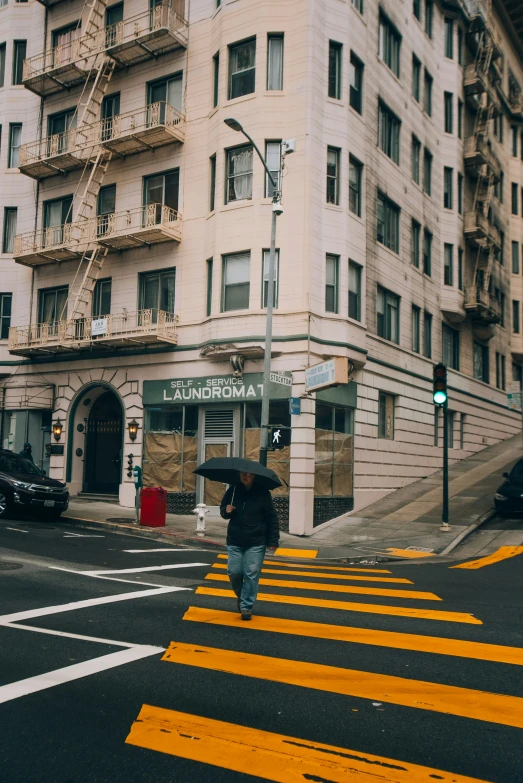 a woman walks down a busy city street with an umbrella