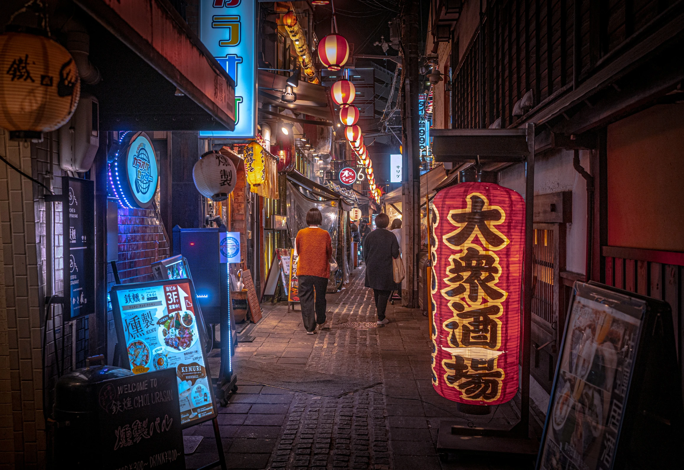 a crowded sidewalk with a bunch of signs lit up