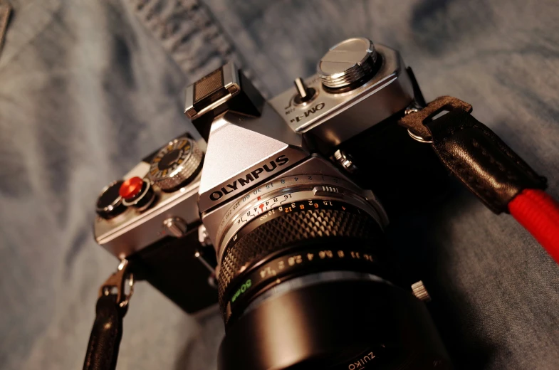 a camera on a bed that has some sort of red handle