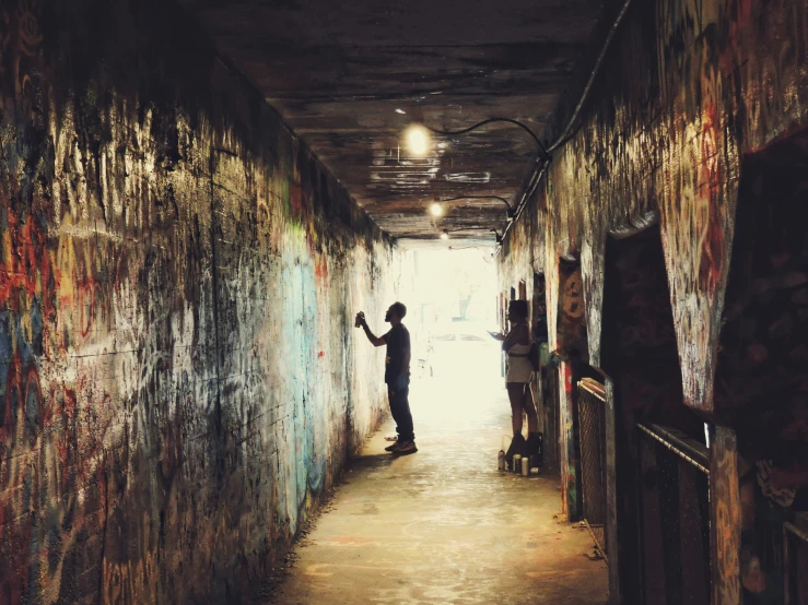 a person painting the wall at the end of a tunnel
