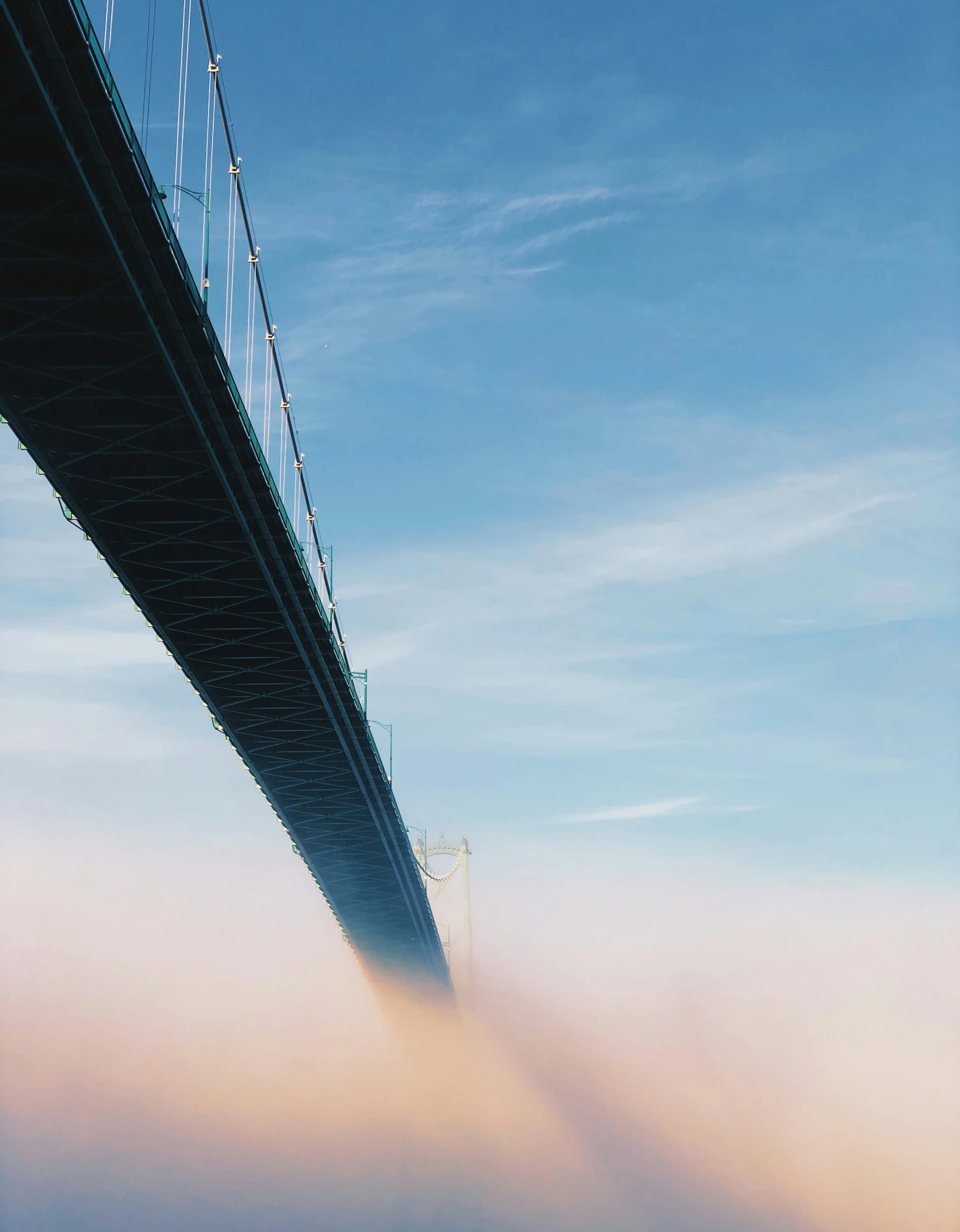 clouds are covering the water under a bridge