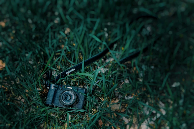 a camera in grass that is on the ground