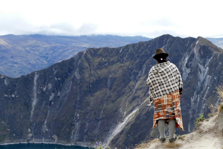 a person standing on top of a hill overlooking mountains