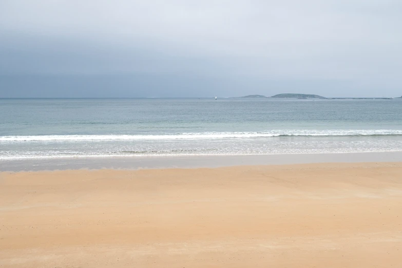 an empty beach with a lone surfboard on it