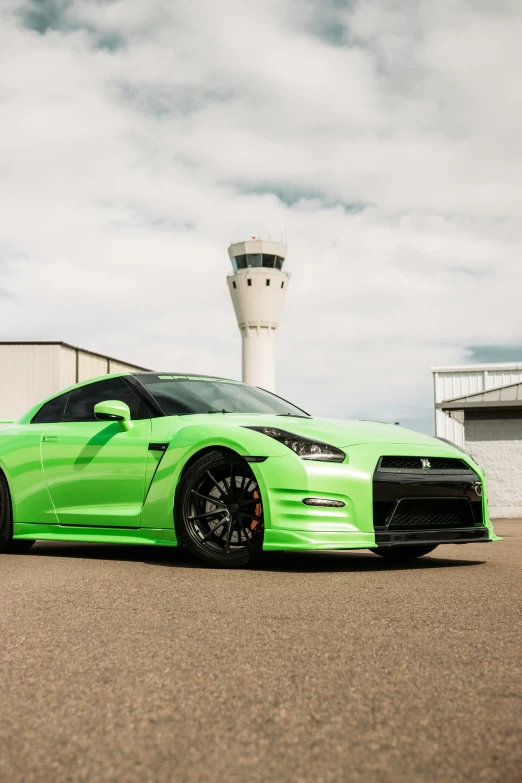 green sports car in front of airport control tower