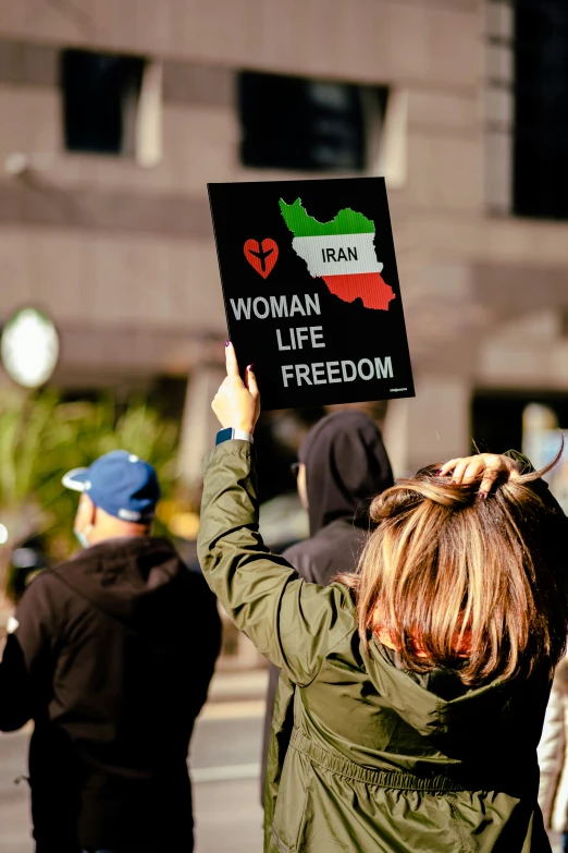 a woman holding up a sign with women in israel