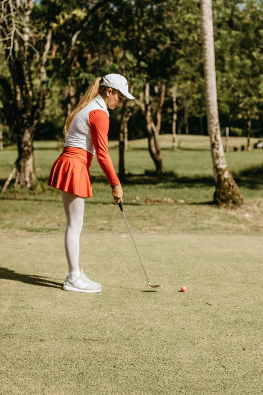 the girl plays in the putting position at the course