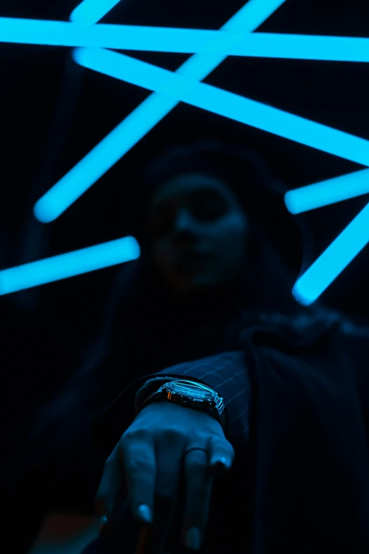 a person wearing a hooded jacket and watch with neon strips of lights