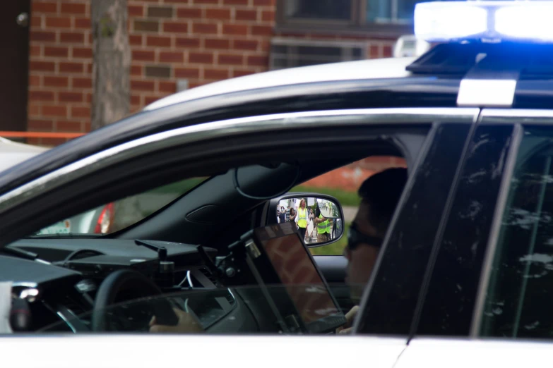 the reflection of a police car in a side view mirror