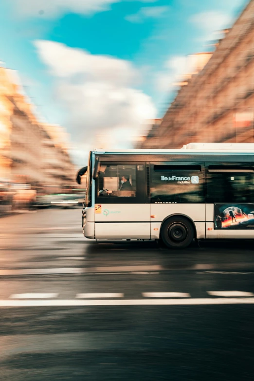 a large bus driving down a street next to tall buildings