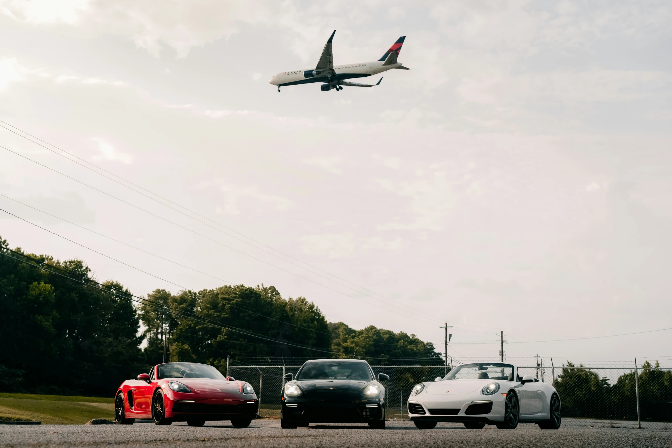 a jet is in the sky over some cars