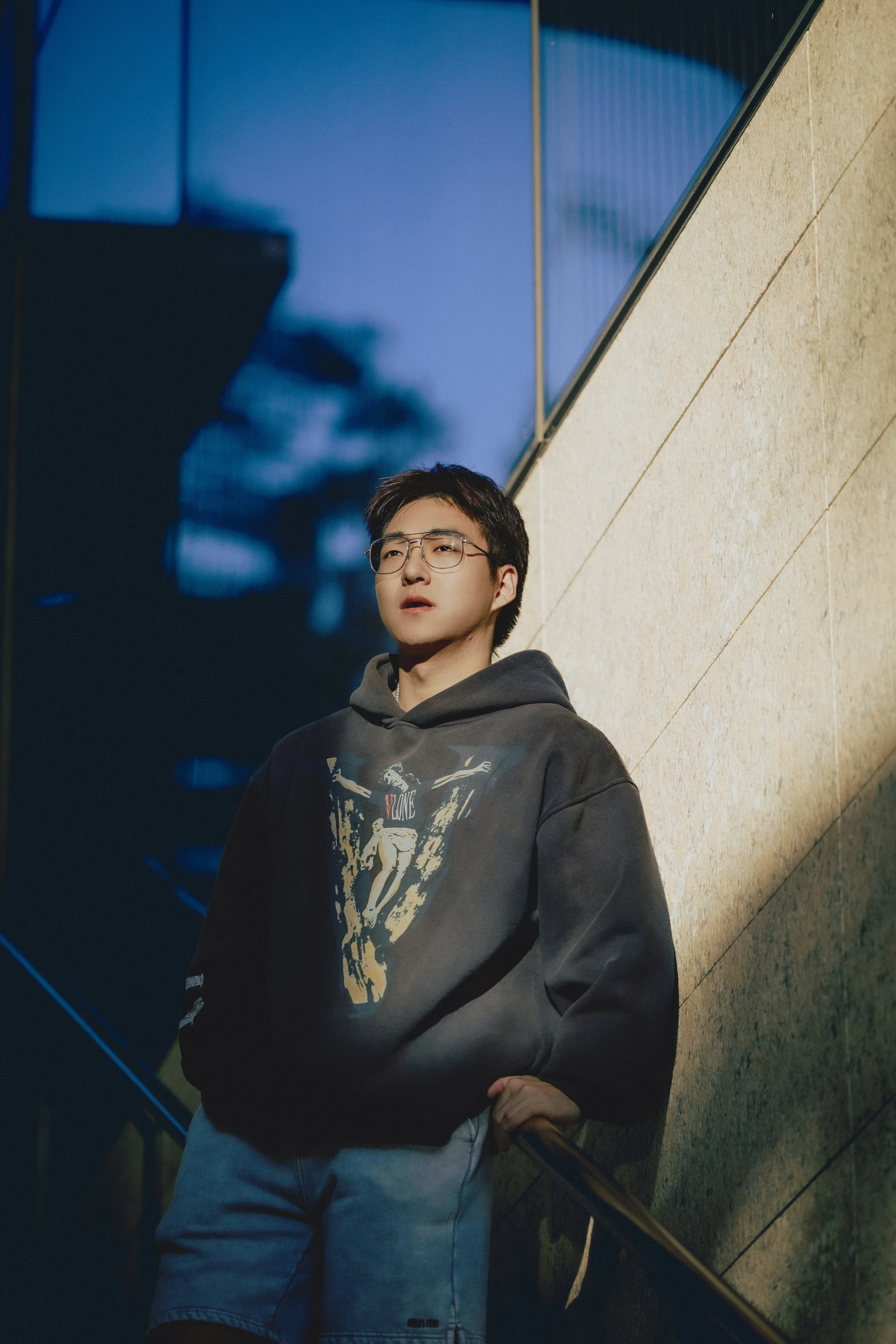 a man is leaning against the wall wearing shorts