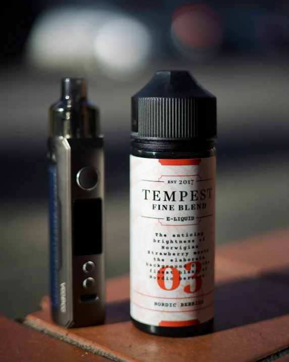 a bottle and a vapor sitting on a wooden table