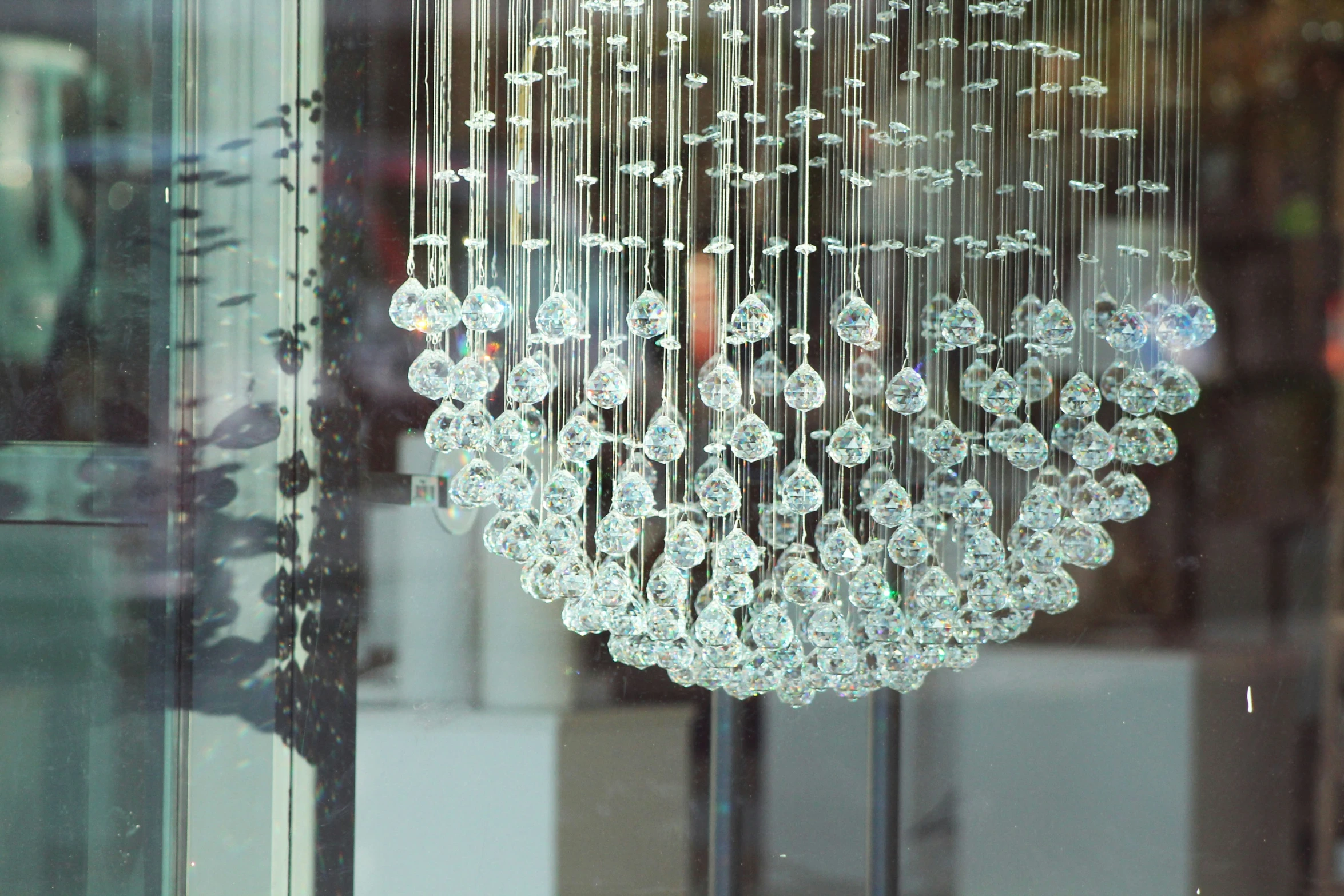 crystal balls are hanging in a chandelier in a shop window