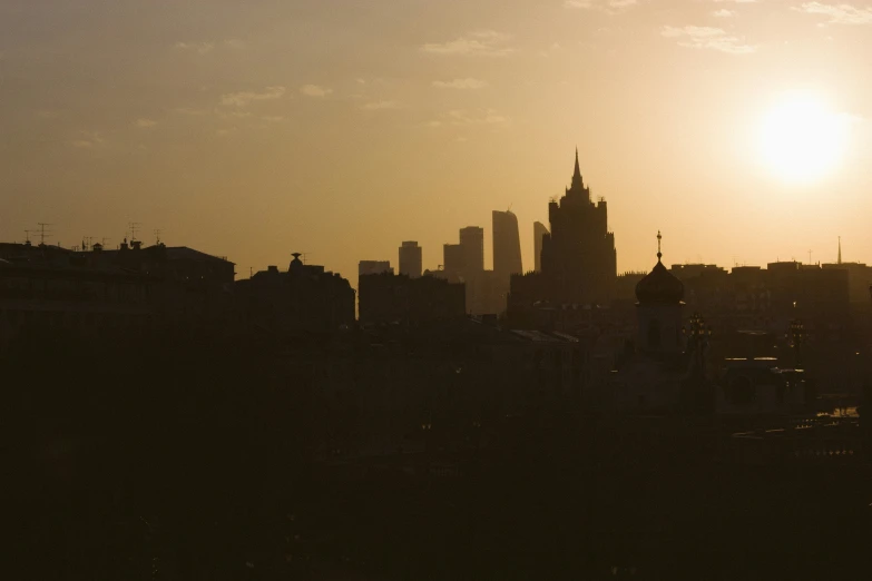 the sun rises over an area with high rise buildings