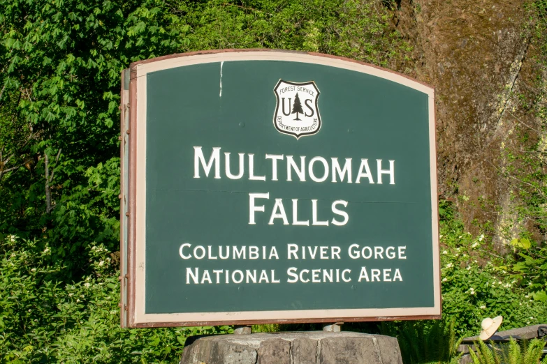 a sign on the side of a road with trees in the background