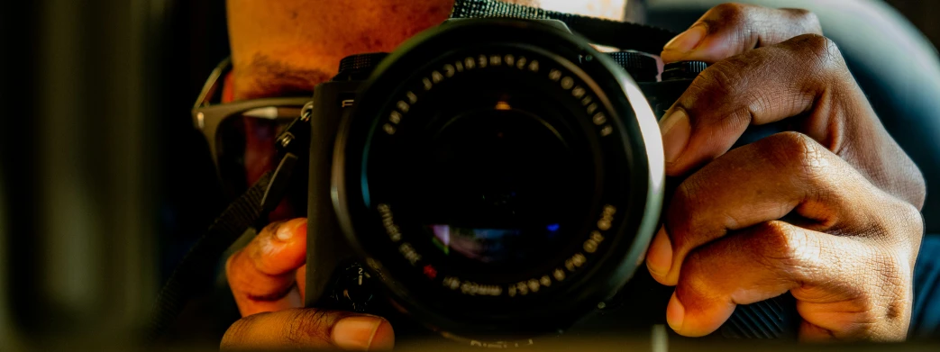 a man holding up a digital camera in front of his face