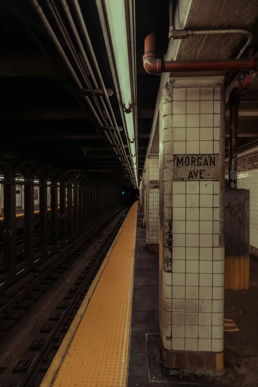 a subway station with a yellow line on the platform