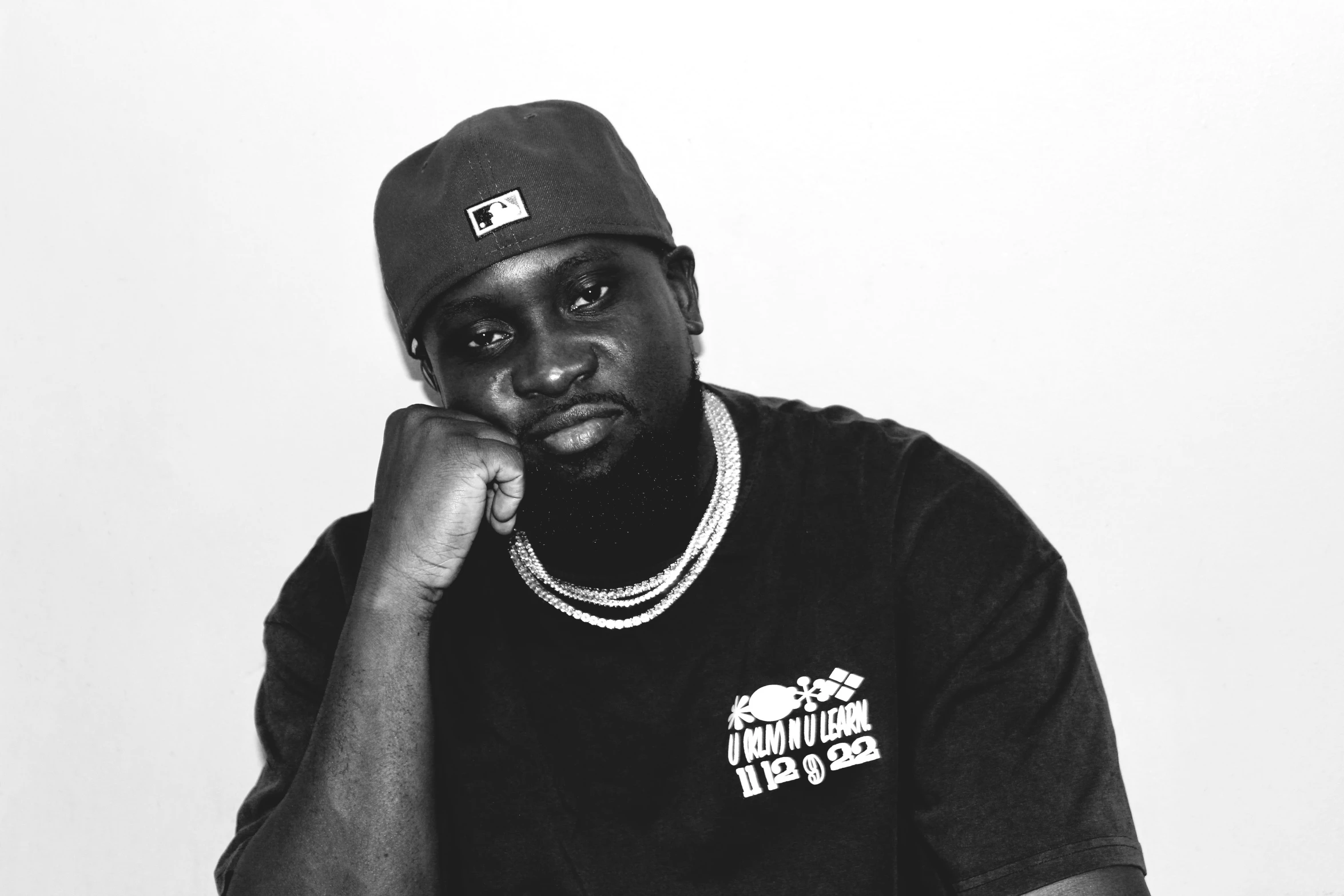 a black and white pograph of a man wearing a hat and shirt