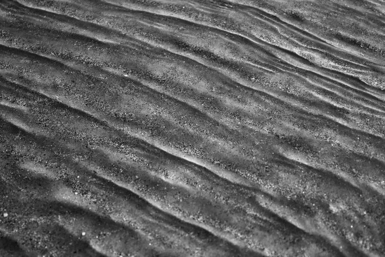 sand moving over it's edges and forming a ripple in the water