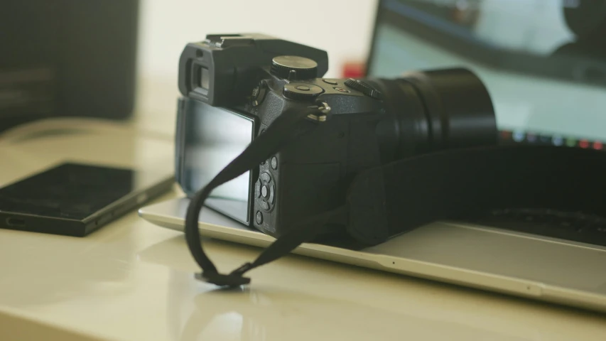 a camera and laptop sitting on a desk