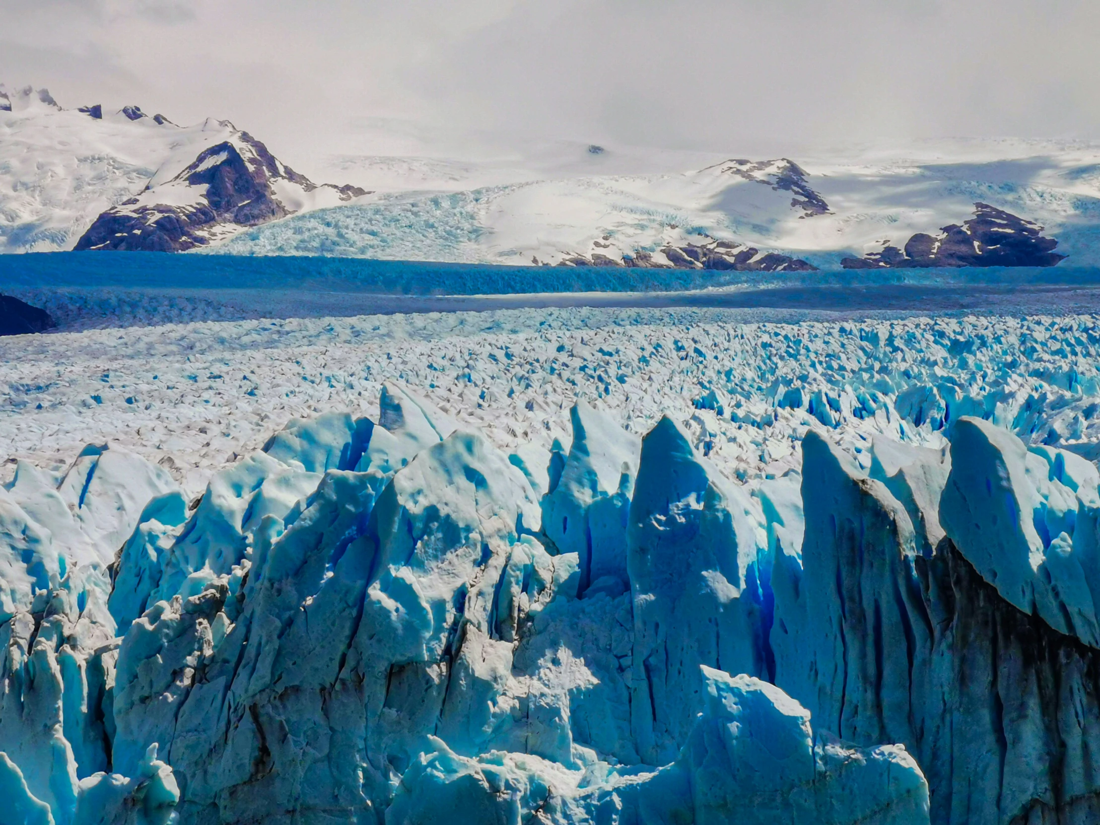 an aerial view of a large glacier and mountains