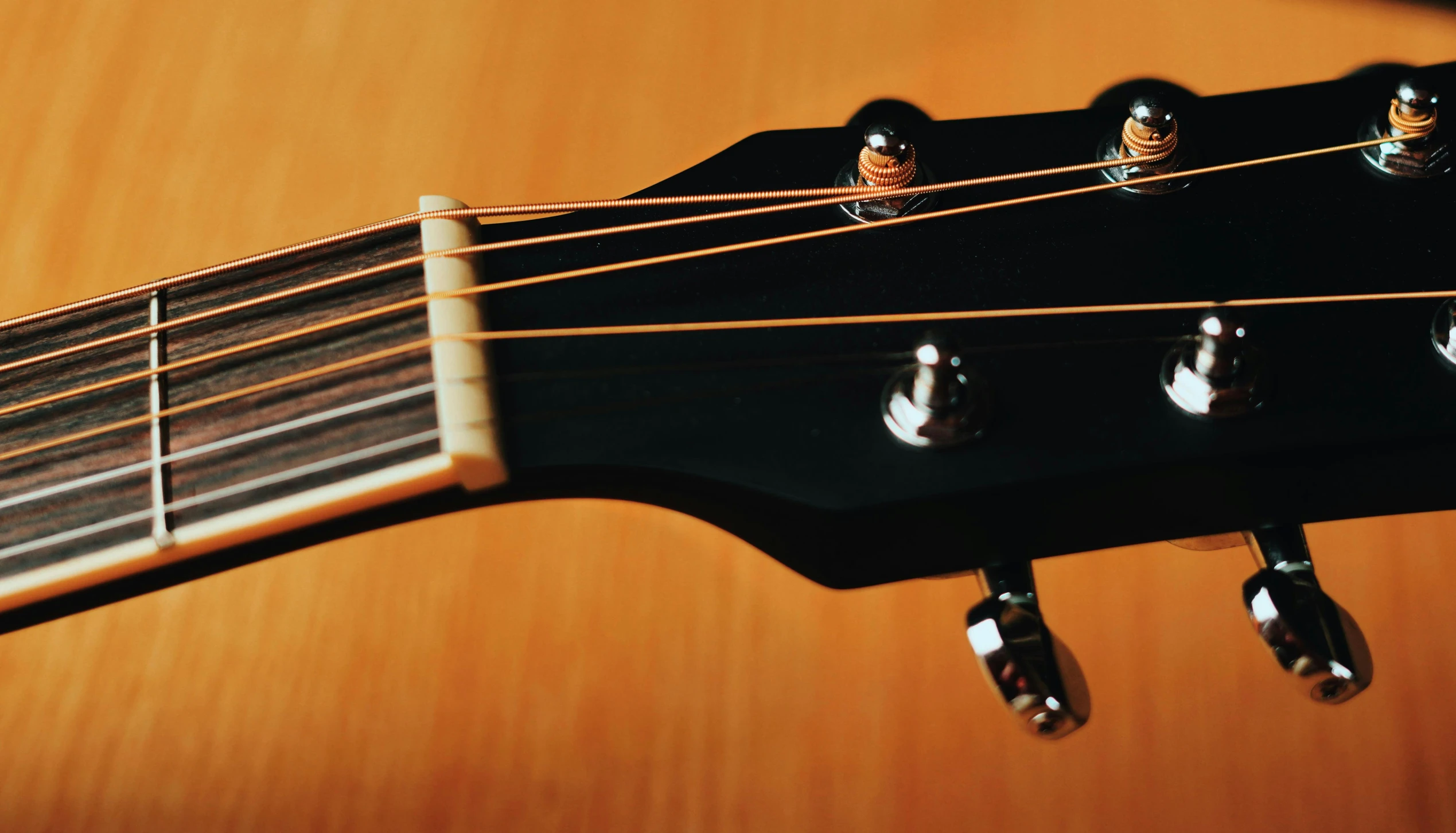 a black acoustic guitar is sitting on the table