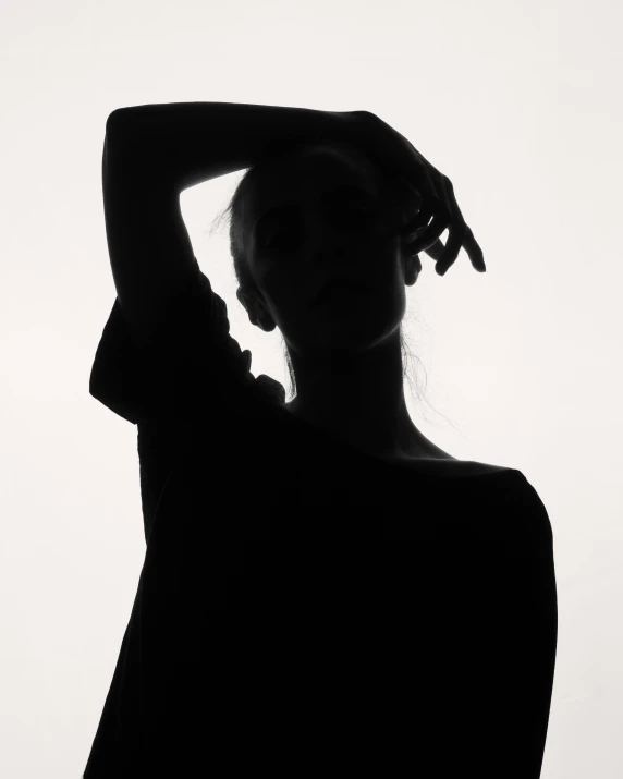 a woman's silhouette in silhouette holding her hair above her head