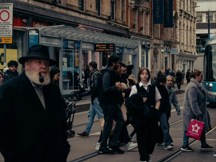 people are waiting for a transit bus on a busy street