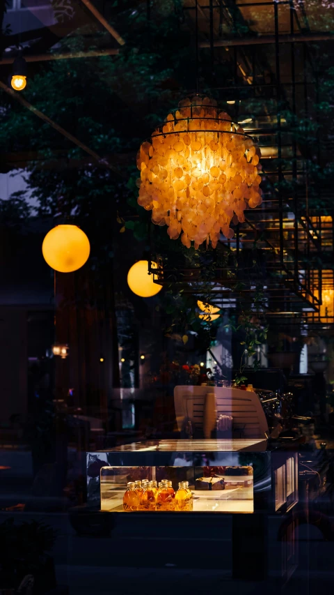 two pendant lights that look like chandeliers in the window of a store