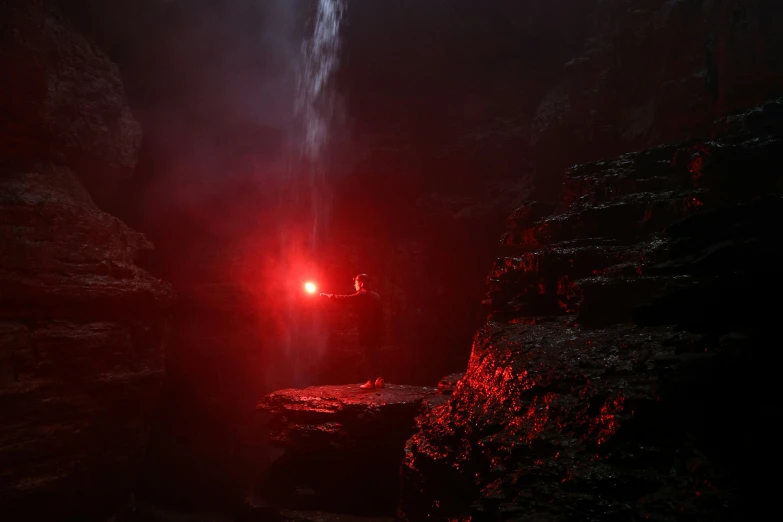 light shining on a dark cave with a waterfall