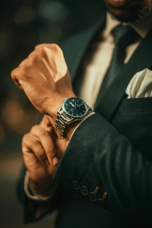 man in suit and tie wearing an elegant blue watch