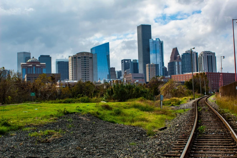 an image of train tracks with city in background