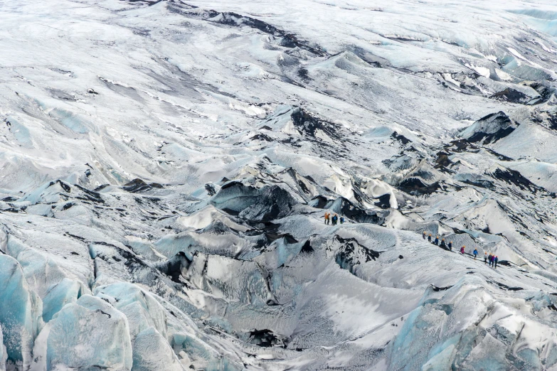 several people standing on the top of an icy mountain