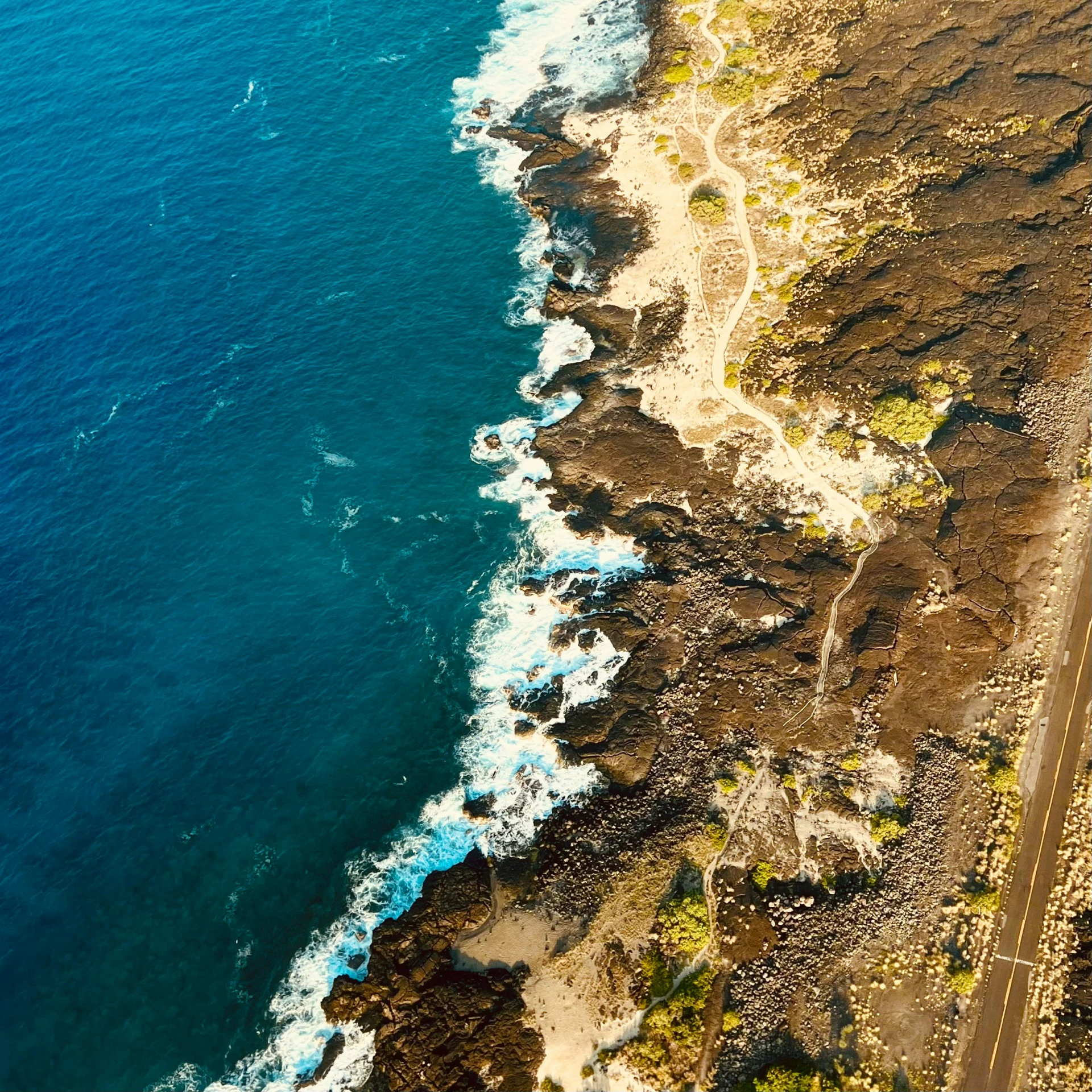 this aerial po shows a road running along the side of the ocean