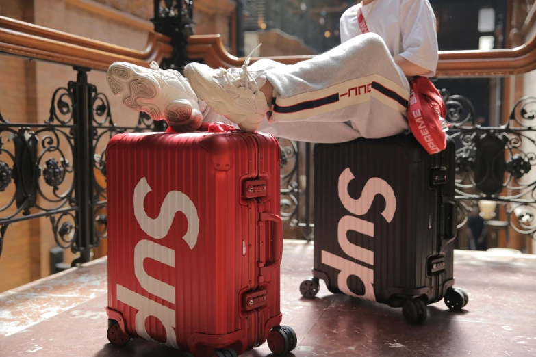 two suitcases sitting on the ground and one with a pair of shoes