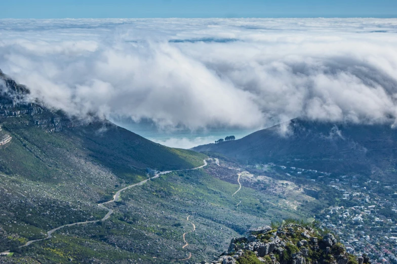 the view looking down at some small hills from a high mountain