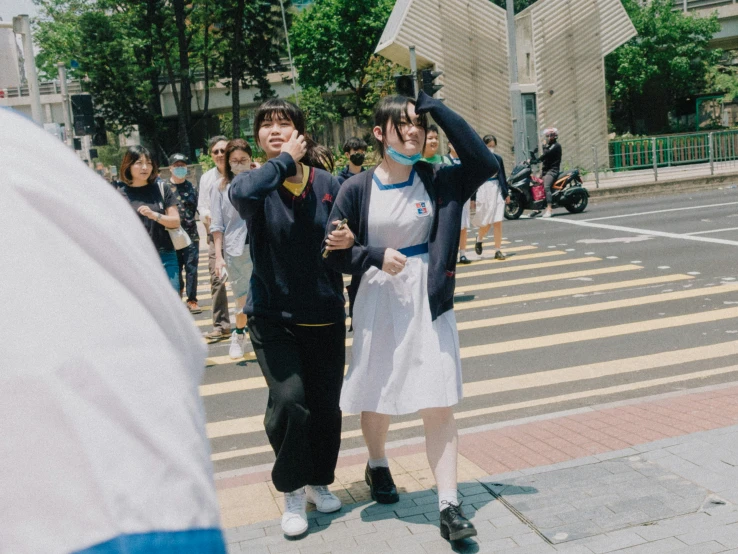 two people standing in the street next to a crosswalk