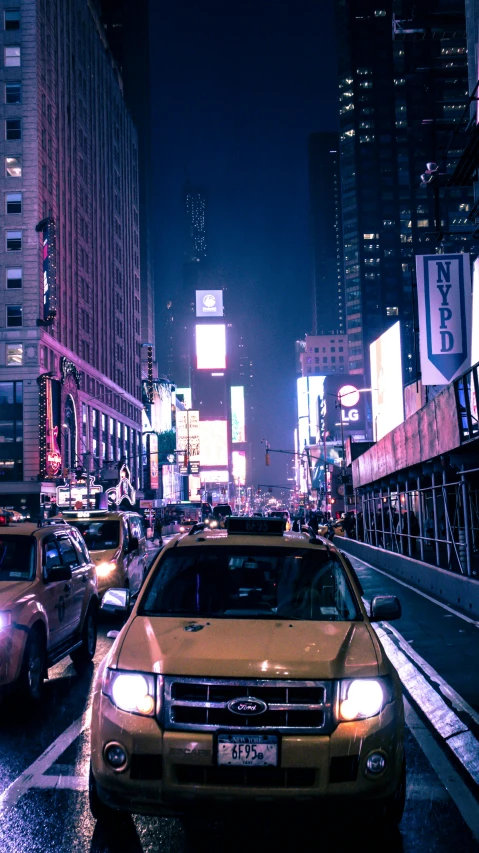 a taxi cab driving through a traffic filled intersection at night