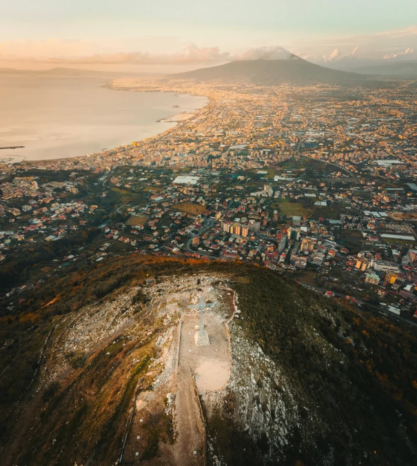 a city in the distance with some mountains and hills behind it