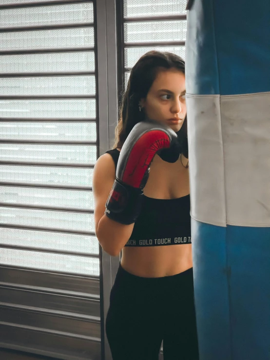 woman in black sports  with red boxing gloves