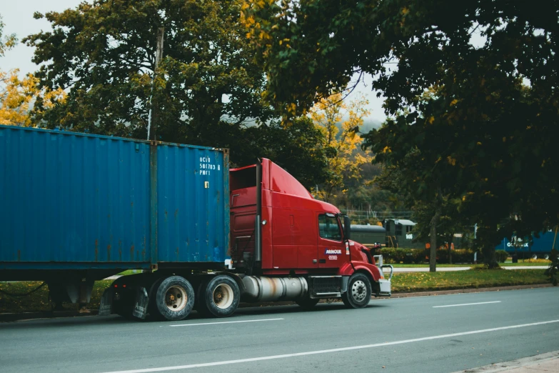 a large semi truck hauling a blue box