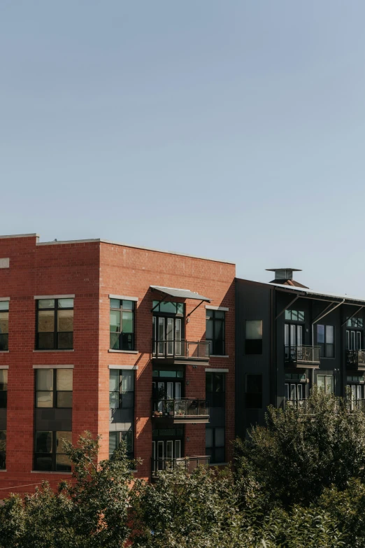 an apartment building with balconies and trees in front of it