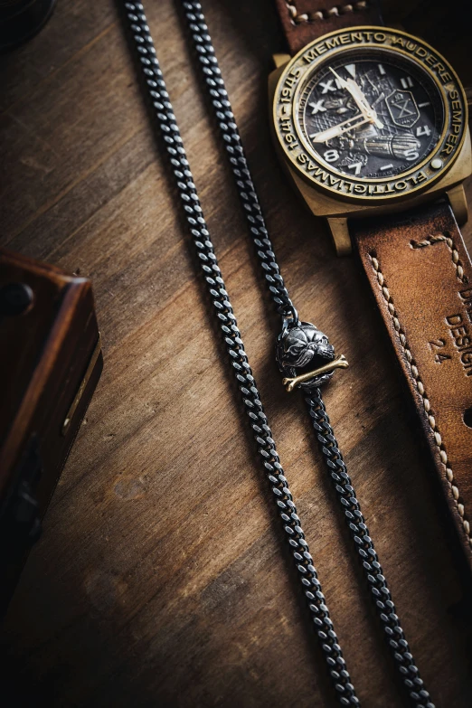 this watch has a chain that is secured by an old leather belt