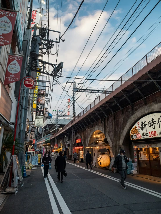 people walking on the street under overhead wires