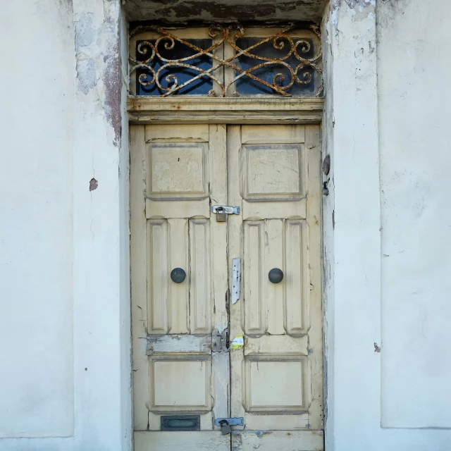 old weathered doors of an ornate white building