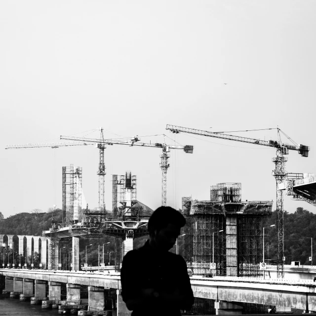 man looking at construction site while holding an electronic