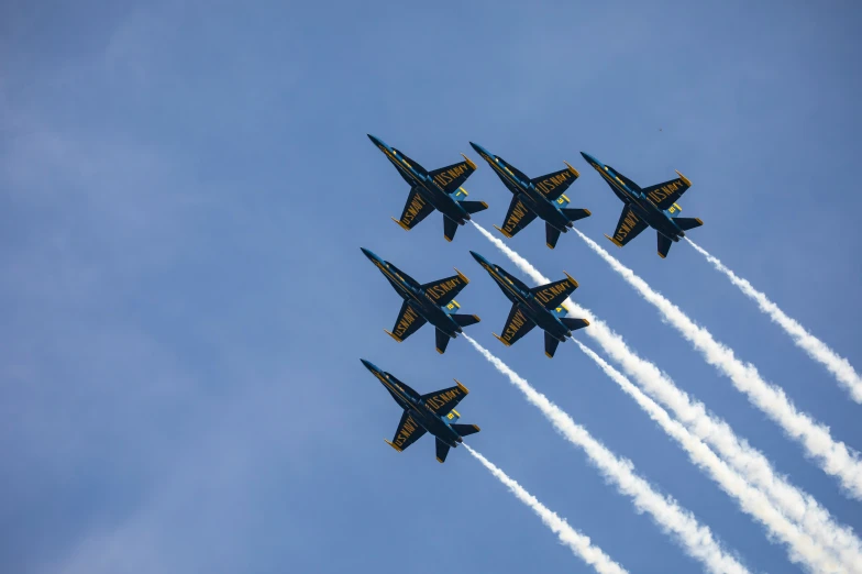 six planes flying in the sky with trails of smoke behind them