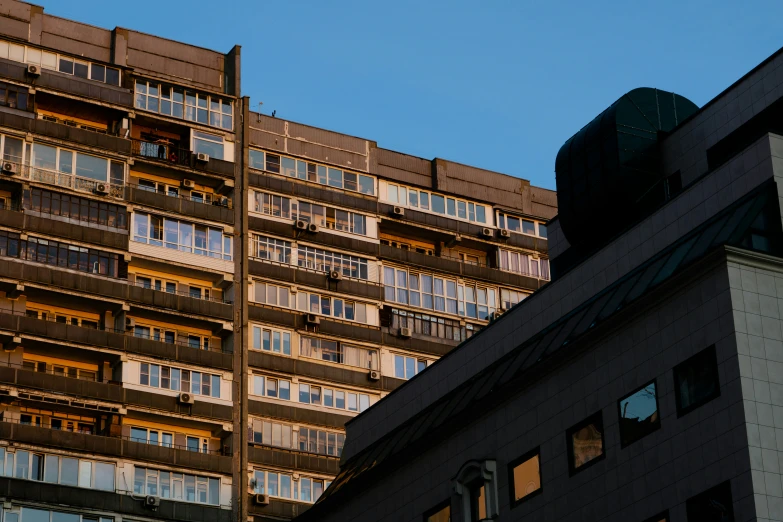 two tall buildings with balconies and an unusual sky scr