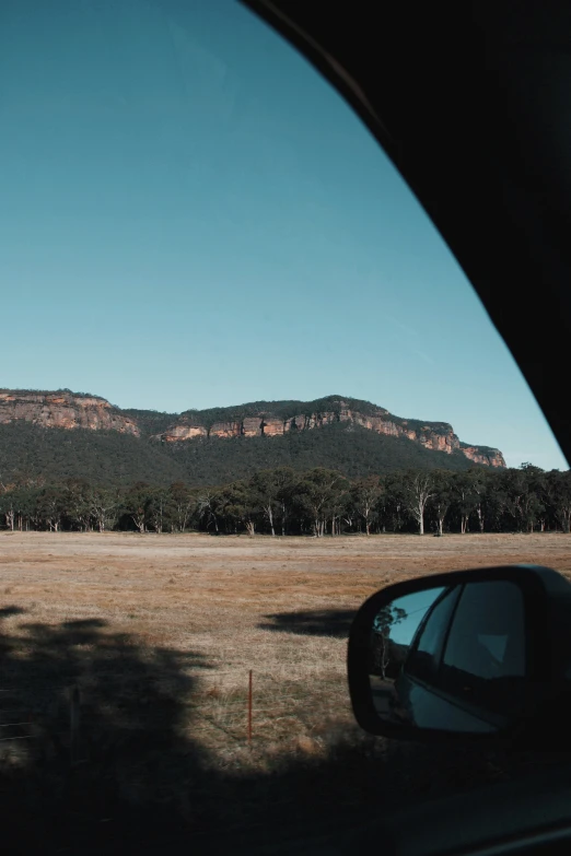 a mountain view from inside a car looking at the desert